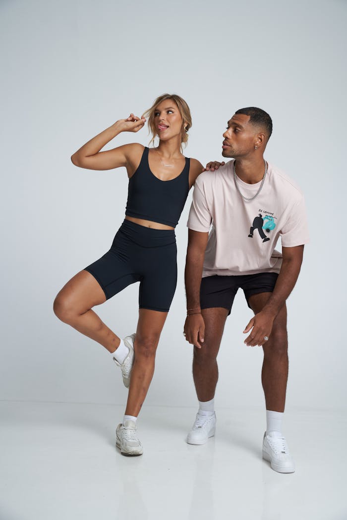 A vibrant fashion shoot featuring two models in athletic sportswear posing energetically.